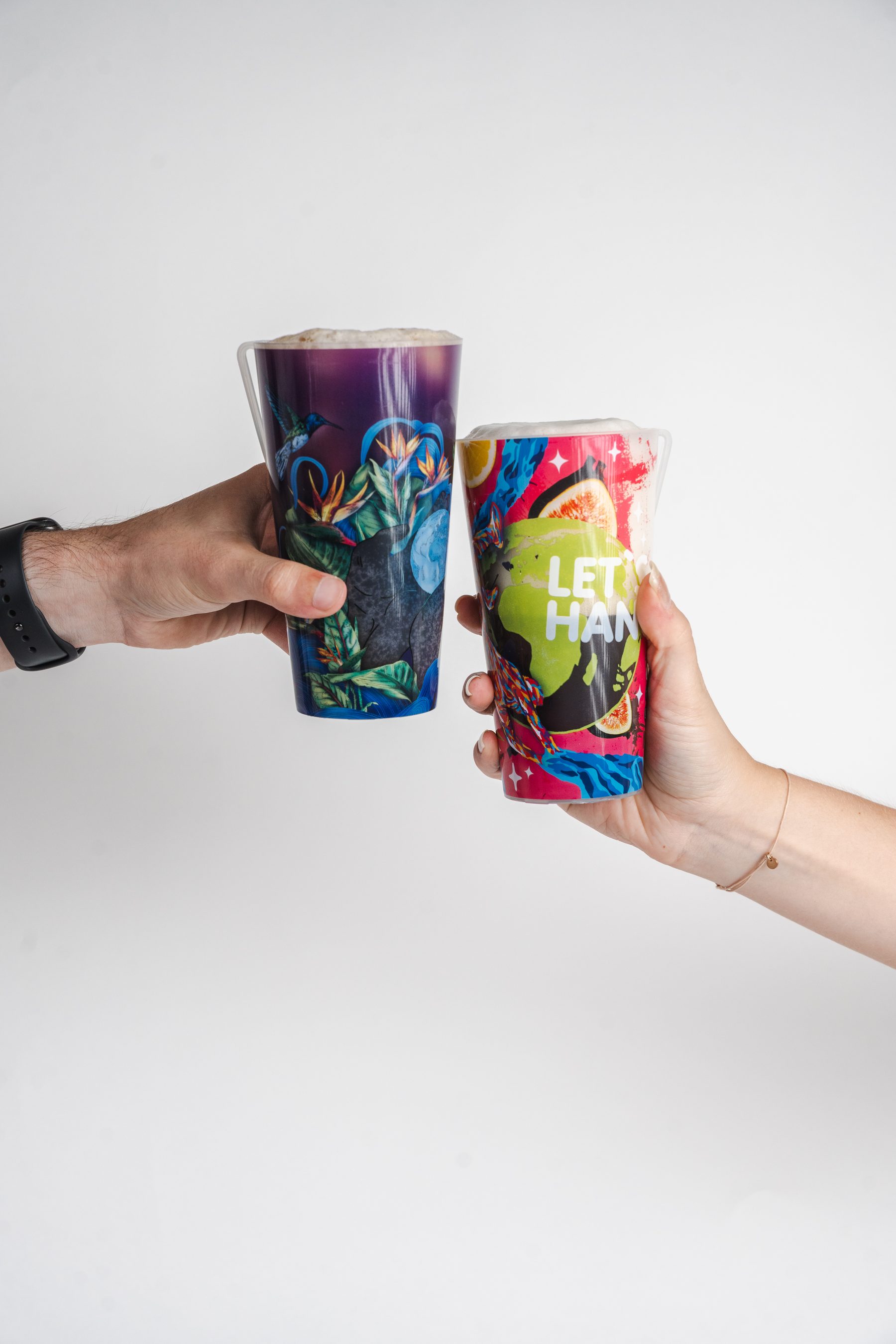 Personas brindando con vasos reutilizables personalizados